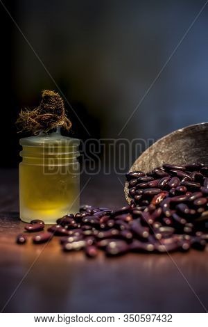 Close Up Of Raw Kidney Beans On Brown Colored Surface In A Clay Bowl And Its Oil In A Small Transpar