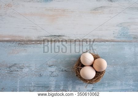 Easter Eggs On Gray Vintage Background. Natural Colored Eggs In A Easter Nest. Flat Lay Photography 