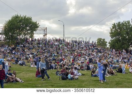 Moscow/ Russia - 16.06.2019: Many People Of Different Sex And Age Are Sitting On The Green Hill Of T