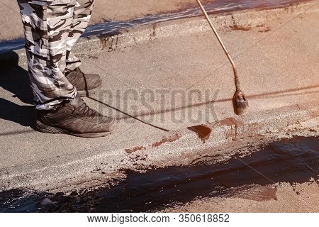 Worker Installing Tar Foil On The Rooftop Of Building. Waterproof System By Gas And Fire Torching. R