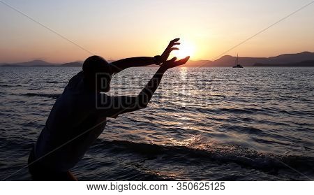 Koral Island / Thailand - January 22, 2020: Mans Hands Catching Sun At Sunset On The Sea Shore