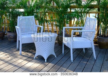 Closeup Of Plastic Weave Chairs And Table In Outdoor Terrace. Wicker Weave Outdoor Plastic Furniture