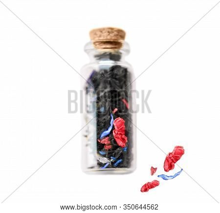 Small Old Vintage Glass Bottle With Cork With Floral Tea And Blue And Pink Petals Inside Isolated On