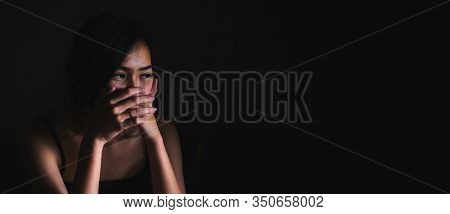 Sad Depressed Woman Suffering From Family Life. Women Sitting In Dark Room And Right Palm Touching H