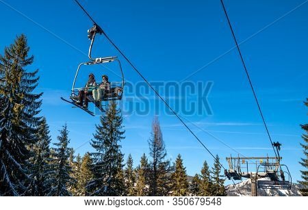 Demanovska Dolina, Slovakia - February 8: Skiers Sitting On Ski Lift Chair In Resort Jasna In Low Ta