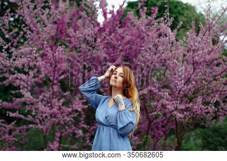 Beautiful Dreaming Redhead Woman In Spring Time Blossom Cherrytrees Garden.