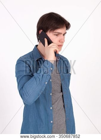 Young Smiling Man Talking On The Mobile Phone And Looking Away. Isolated On White.
