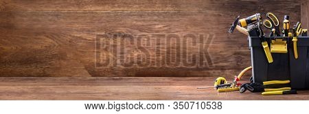 Toolbox With Various Worktools On Wooden Surface