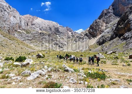Turkey, Chamard - August 3, 2019: Tourists Walk Along The Road Through The Mountain Landscape In The