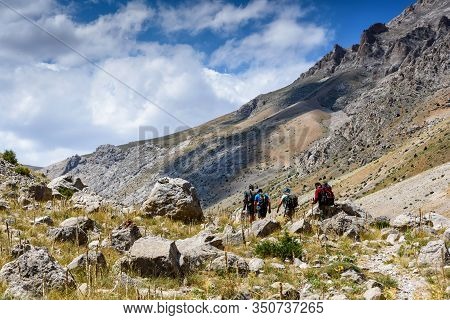 Turkey, Chamard - August 3, 2019: Tourists Walk Along The Road Through The Mountain Landscape In The