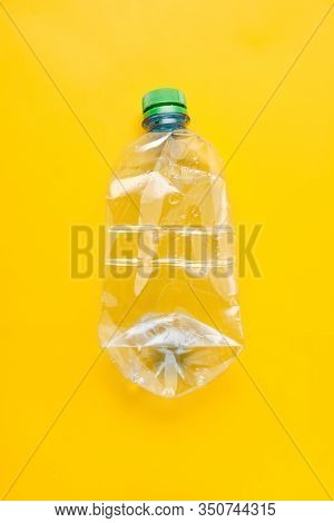 Used Plastic Bottle Of Water With Caps On Yellow Background. Recycling Concept