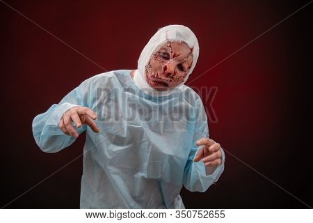 Crazy Zombie Horror Make Up. Person In Blue Madical Shirt And Bandaged Head. Scars, Deep Scratches R