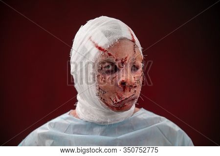 Crazy Zombie Horror Make Up. Person In Blue Madical Shirt And Bandaged Head. Scars, Deep Scratches R
