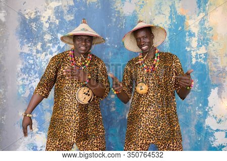 Handsome African Men In Traditional Fulani Hats And Colorful Posing At Studio.
