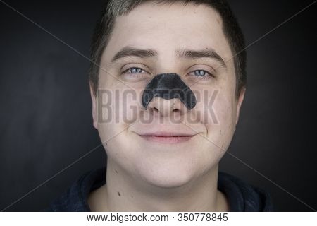 A Man Puts On And Removes A Strip For The Nose From Black Dots. Coal Cleaning Strips From Blackheads