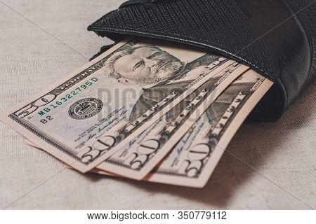 Black Wallet With Dollars 50 On A Gray Background.