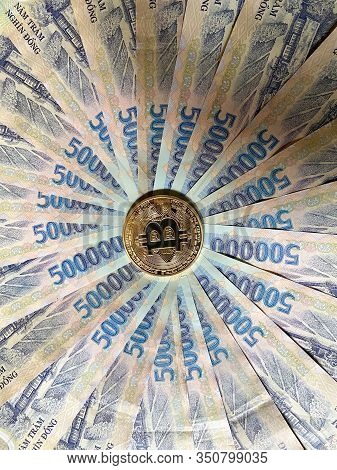 A Golden Bitcoin On Vietnamese Billnotes