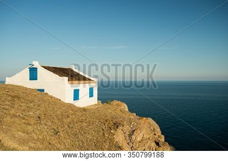 Old White House With Closed Windows Painted Blue Wooden Board On Coast Of Black Sea On Sunny Day In 