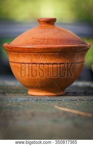 Clay Orange Gaiwan For Brewing Tea. Photo Of Tea Utensils On A Background Of Nature