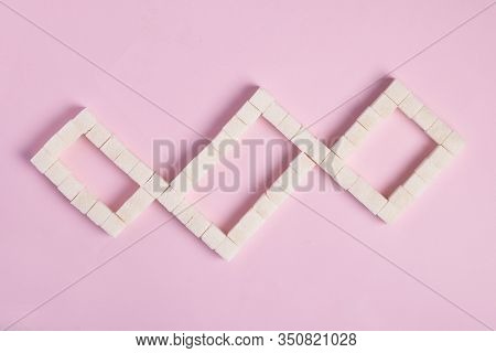 White Sugar Cubes On Pink Background. Top View. Diet Unhealty Sweet Addiction Concept