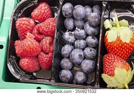 Fresh Berries Are Packed In Trays. Vitamin-rich Fruits Are Packaged In Boxes. A Variety Of Fruits Fo