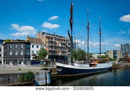 Ship moored in Willemdock in Antwerp. View of Bonapartedok harbor and vintage galleon. Antwerpen, Belgium, Europe, Flanders