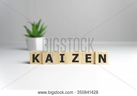 Kaizen Improvement Sign Made Of Blocks On A Wooden Desk In A Bright Room