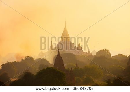 Scenic sunset with Ananda temple silhouette and thousands of historic buddhist pagodas and stupas in Bagan Archeological area in Myanmar