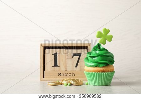 Delicious Decorated Cupcake, Wooden Block Calendar And Coins On Light Table. St. Patrick's Day Celeb