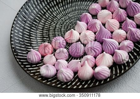 Meringue On A Black Round Plate With An Ornament