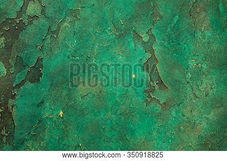 Wall With Relief Decorative Art Plaster Painted In Malachite Green Paint With Golden Yellow Streaks.