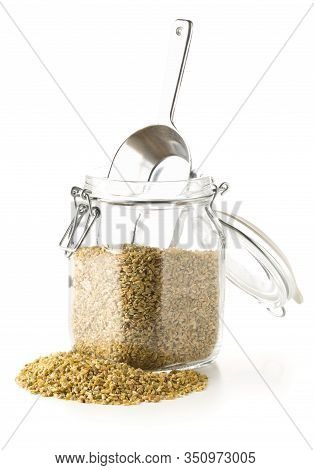 Heap Of Uncooked, Raw Freekeh Or Firik, Roasted Wheat Grain, In Glass Storage Jar With Metal Scoop O