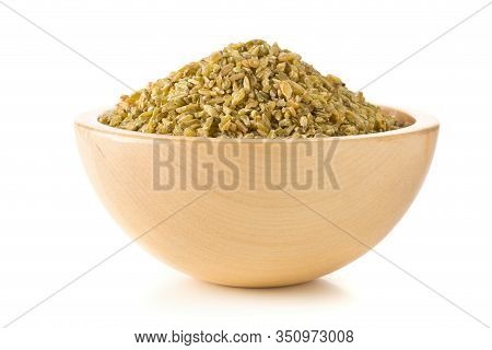 Heap Of Uncooked, Raw Freekeh Or Firik, Roasted Wheat Grain, In Wooden Bowl Over White Background