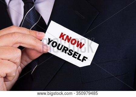 .businessman Putting A Card With Text Know Yourself In The Pocket