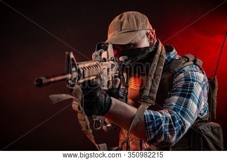 A Police Agent In Civilian Clothes And Armor With An Automatic Rifle