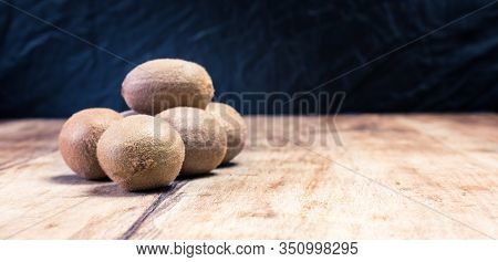The Kiwi Fruit On A Wooden Table And Black Background