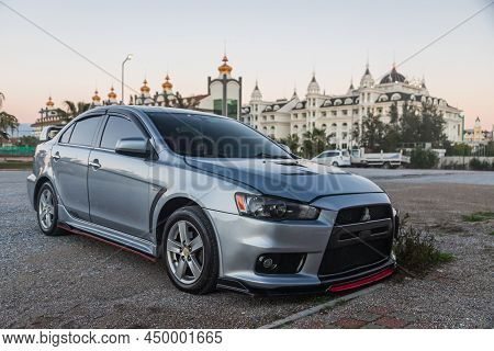 Side, Turkey - February 02 2022:  Silver Mitsubishi Lancer    Is Parked  On The Street On A Warm  Au