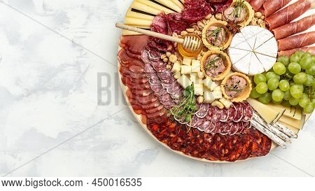 Antipasto Platter Of Various Types Of Soft And Hard Cheese. Spanish Manchego Cheese, Ham, Prosciutto