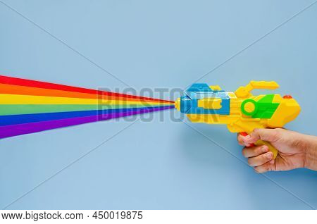 Hand Holding Water Gun Spray Out With Colorful Cutting Paper For Songkran Festival Celebration On Bl