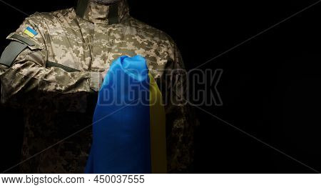 Ukrainian Soldier Holds A Flag Of The Independent State Of Ukraine. Steadfastness And Courage Of The
