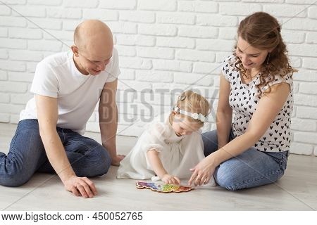Baby Child With Hearing Aids And Cochlear Implants Plays With Parents On Floor. Deaf And Rehabilitat