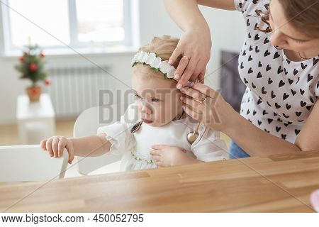 Mother Helps To Put On Cochlear Implant For Her Deaf Little Daughter. Hearing Aid And Deafness Conce