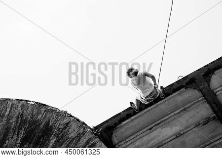 Woman Practicing Rappel On A Pedestrian Walkway.