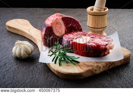 Raw Osso Buco Steak Lies On Waxpaper. Fresh Veal Shank Meat Cut With Marrow Bone Served At Wooden Bo