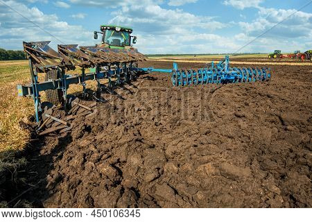 Bilogirya, Khmelnytskyi Region, Ukraine - August 19, 2021: Farm Tractor Pulls Plow Lemken, Preparing
