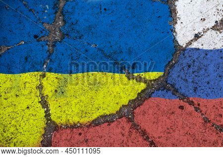 The Concept Of Confratation. On The Cracked Texture Of The Asphalt, Images Of The Flags Of Ukraine A