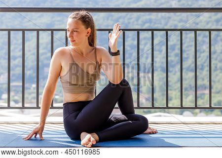 Young Woman Stretching At The Balcony Doing Her Morning Yoga Routine