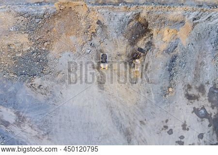 Aerial Top View In Industrial Escavation Equipment Of Big Yellow Truck Inside A Granite Quarry To Lo