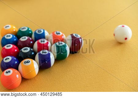 Man Cue Aiming On Billiard Ball At Table. Snooker Or Pool Billiard Equipment Of Colorful Balls With