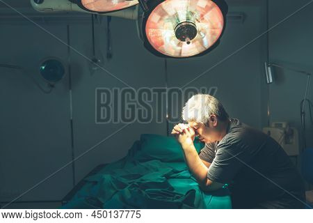 Asian Man Crashing Down On The Patient's Bed In Operating Room, Because He Was Sad From The Departur